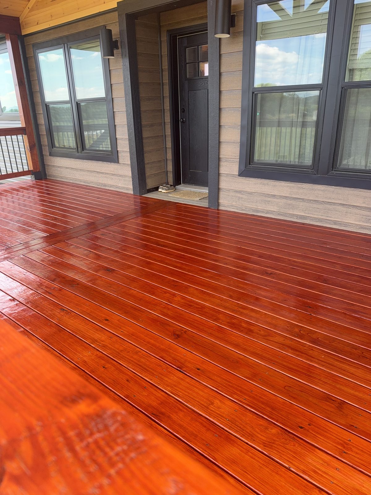 ProLuxe Mahogany deck boards reflecting the dark siding and windows of a modern Piney Flats home