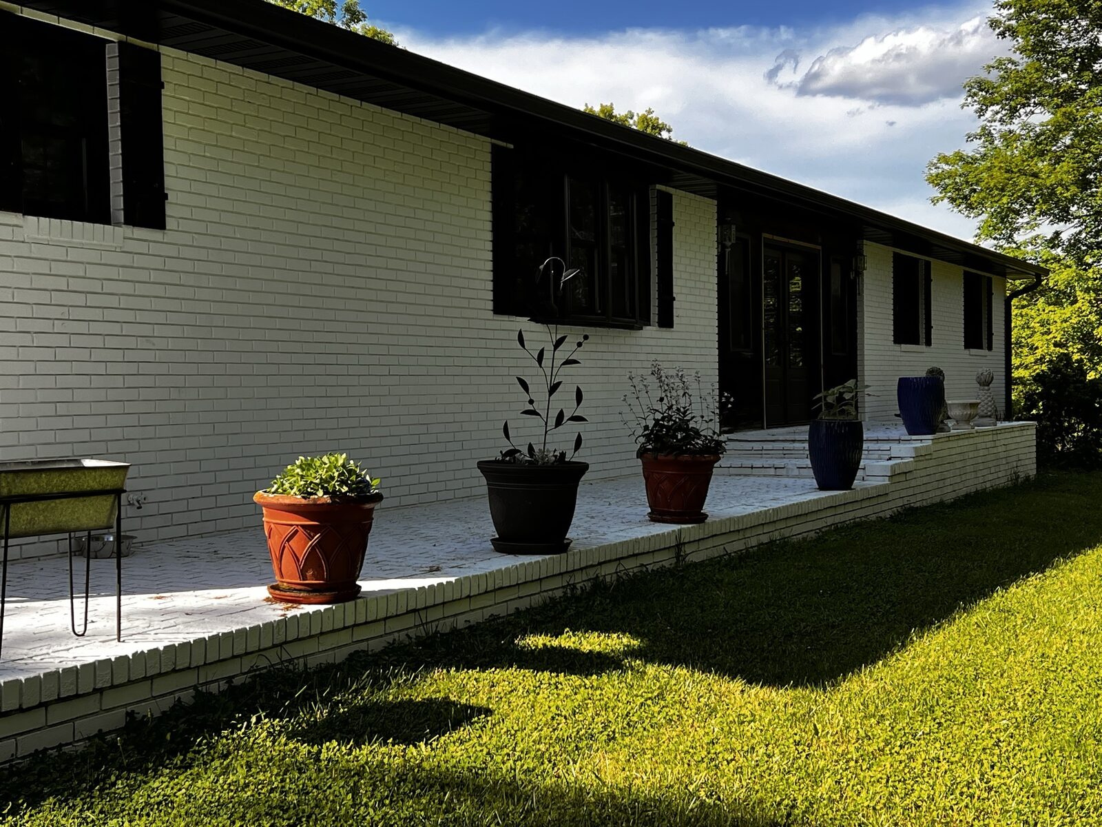 Wraparound porch and back patio of finished Romabio Masonry Flat brick home