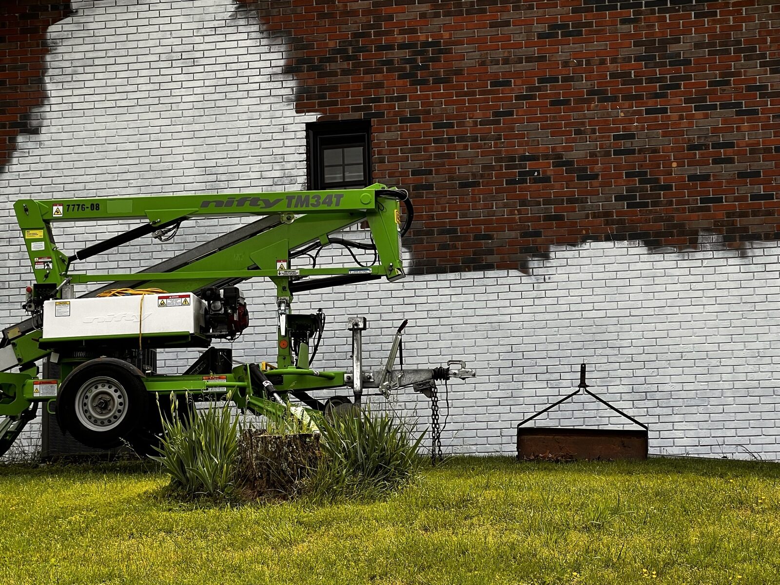 Mid-application of Romabio Masonry Flat on Tri-Cities brick home with cherry picker lift